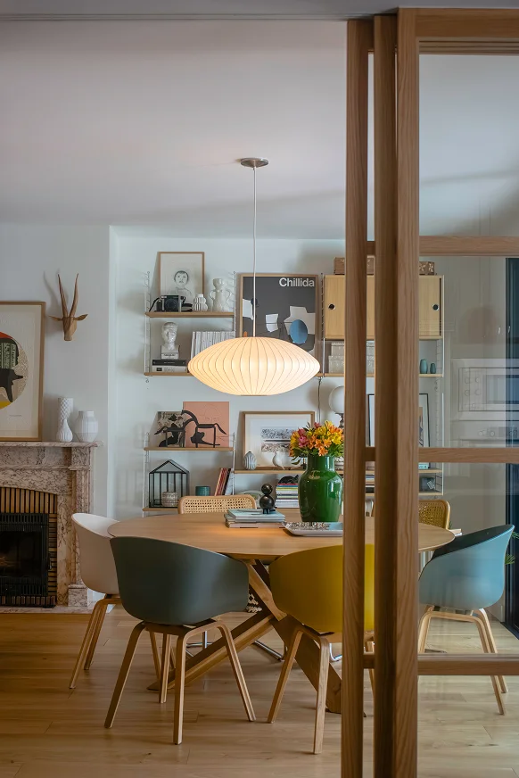 Sinpar Studio — Comedor redondo con sillas de colores y chimenea reforma chalet Pozuelo