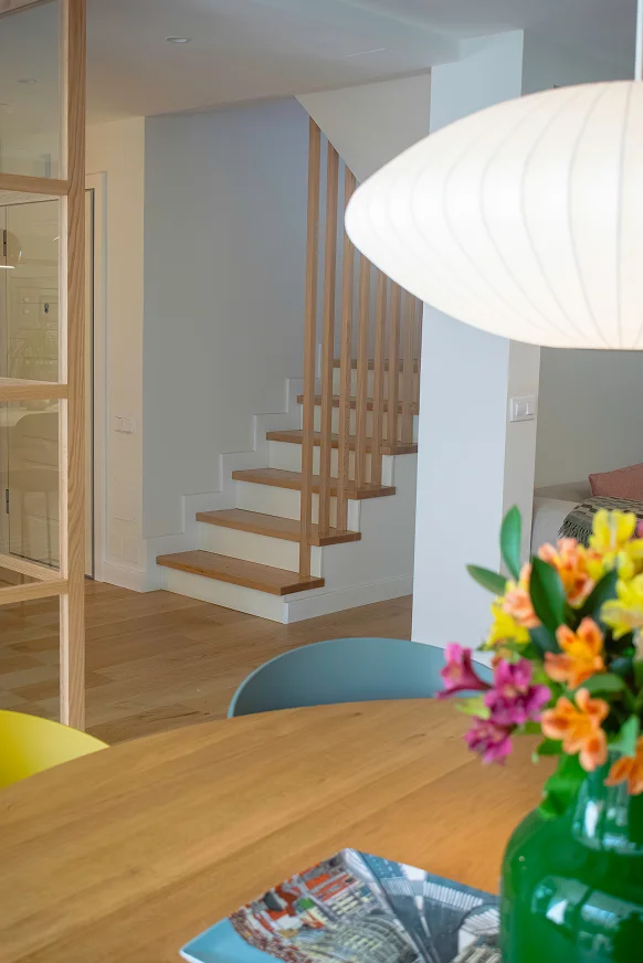 Sinpar Studio — Escalera con barandilla palilleria madera tras comedor reforma chalet Pozuelo
