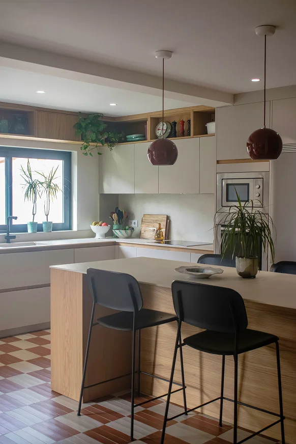 Sinpar Studio — Isla cocina con taburetes negros y suelo ajedrez reforma chalet Pozuelo