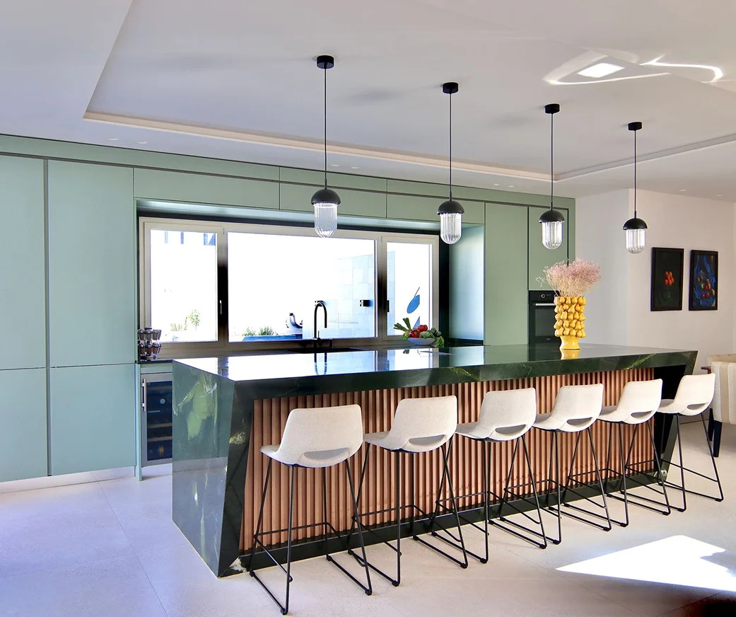 Sinpar Studio — Cocina con isla verde esmeralda y taburetes blancos reforma chalet Toledo