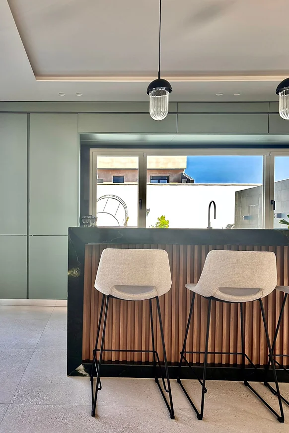 Sinpar Studio — Isla verde esmeralda con revestimiento listones madera cocina reforma chalet Toledo